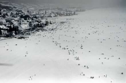 Schneebedeckte Eisdecke mit vielen Leuten drauf.