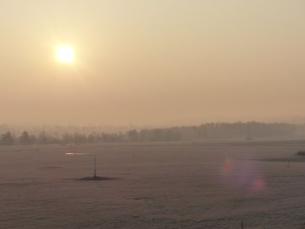 Kurz nach Sonnenaufgang am Flughafen Zürich. Eine dunstige Grundschicht lässt in der Ferne jede weitere Wald- und Hügelkette zunehmend verblassen. Horizontale Sichtweite bei der Aufnahme: 4000 Meter.