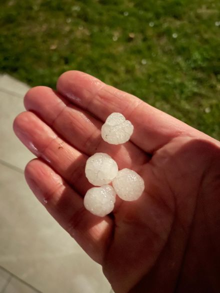 Kleine Hagelkörner in einer Hand.