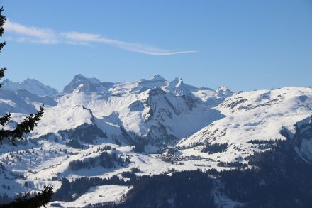 Foto mit schneebedeckten Bergen. In der Bildmitte befindet sich das Skigebiet Stoos. Im Hintergrund ist der Berg Uri Rotstock zu sehen. 
