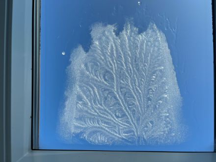Eisblumen an einem Badezimmerfenster. 