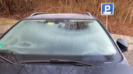 Dünner Eisfilm auf Autoscheibe.