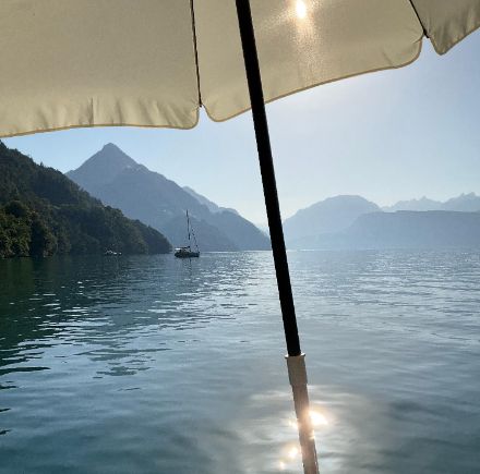   Schatten oder ein Sprung ins kühle Nass hilft, die Hitze etwas erträglicher zu machen. Unter diesem Sonnenschirm im Vierwaldstädtersee bei Ennetbürgen ist sogar beides gleichzeitig möglich.  