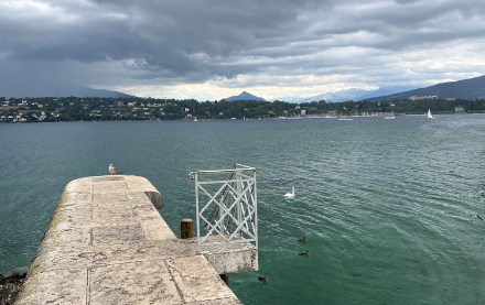 Genfersee mit Hafenmauer, dunkle Wolken am Himmel