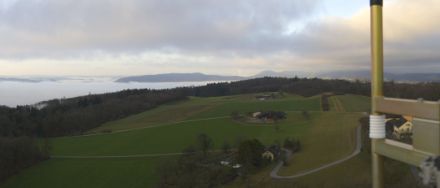 Blick vom Wasserturm bei Baden Richtung Westen. In der rechten Bildhälfte ist zu sehen, wie der Hochnebel praktisch ungehindert über den Aargauer Jura strömt. Auf der linken Bildhälfte ist im Hintergrund das Mittelland zu sehen, welches im Schutz des weiter westlich gelegenen, höheren Juras liegt. Allerdings sorgte dort der klare Himmel (fehlende Hochnebel) dazu, dass sich in der Nacht Nebelfelder bilden konnte. 