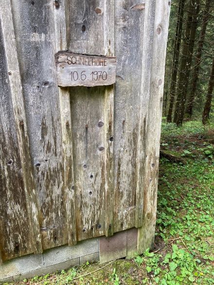Hölzerner Hinweis auf einem Stall, in einem Wald gelegen, oberhalb Ebnat-Kappel im Toggenburg, auf rund 1000 m ü. M. Das Hinweisschild ist auf ca. 1.5 m montiert. 
