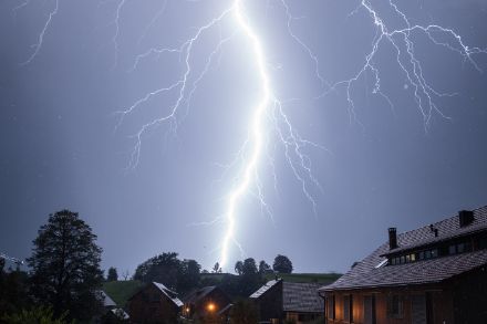 Sehr naher und heftiger Blitzeinschlag, aufgenommen aus einer Dachlukarne. 
