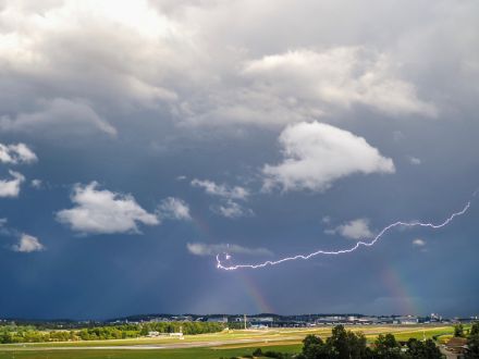 Gewitteraufnahme mit Doppelregenbogen und Blitz am Flughafen Zürich am 1.9.2023. 