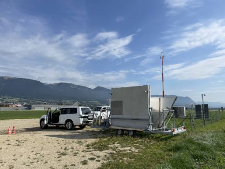 Der mobile Radar-Windprofiler im Transportzustand, auf einem weitläufigen Feld, bereit für seine Rückkehr nach Payerne.