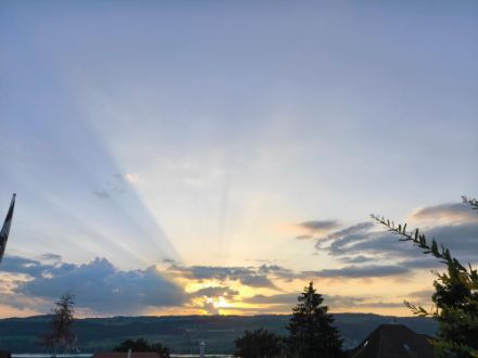 Sonnenaufgang mit sichtbaren Sonnenstrahlen am Himmel
