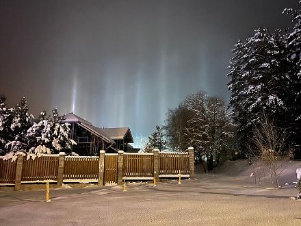 An diesem Ort in Belarus verursacht ganz leichter Schneefall in Form von Eiskristallen Lichtsäulen über den Lampen.