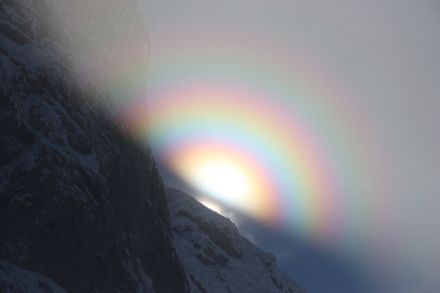 Hof mit farbigen Kränzen um die Sonne, fotografiert bei sehr hoher Nebelobergrenze. 