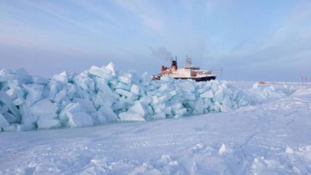 Ein neuer Presseisrücken entsteht auf einer Eissscholle. Im Hintergrund ist der Forschungseisbrecher Polarstern zu sehen. 