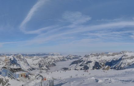 Blick von einem sonnigen Skigebiet auf ein Tal mit Hochnebel