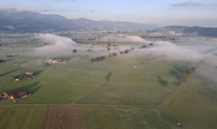 Blick aus einem Heissluftballon über die Linthebene, wo sich in der Nacht flache Bodennebelfelder bildeten. Wenig Wind sorgte dann am frühen Morgen für die Bildung der Wellenstruktur im Bodennebel. Zu viel Bise wäre auch für Ballonfahrer nicht praktisch, da es Starts oder Landungen erschweren oder verhindern kann.