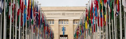 Die Frontseite des Palais des Nations in Genf mit Flaggen.