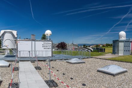  	Bild vom Dach eines Gebäudes, auf dem verschiedene technischen Installationen zu erkennen sind.