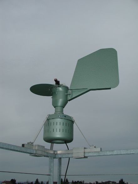 Bild einer volumetrischen Pollenfalle, erkennbar die Ansaugöffnung und die Windfahne; im Hintergrund der Zürichsee.