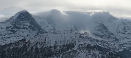 Blick von der Schynige Platte zum Berner Oberländer Dreigestirn Eiger, Mönch und Jungfrau bei Gugiföhn. Das Webcambild zeigt schön die Föhnmauer. Im Vordergrund sind am Lauberhorn Schneefahnen zu erkennen.
