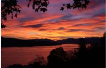 Vordergrund Zürichsee, Blick Richtung Osten mit orangem, roten Himmer / leicht bewölkt.