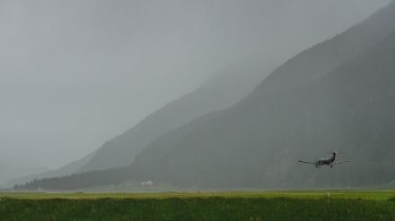 Bild der Landebahn des Flughafens Samedan. Die Landschaft im Hintergrund ist aufgrund des starken Regens nur undeutlich zu erkennen.