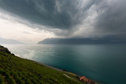 Das Foto zeigt eine Gewitterfront mit düsteren Wolken, wie sie über den Genfersee in Richtung Schweiz zieht.
