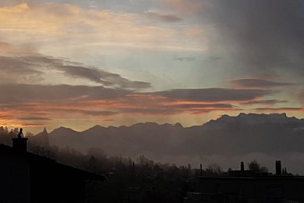 Sicht von Männedorf zum Glärnisch. Mittelhohe Wolken im Licht der aufgehenden Sonne.
