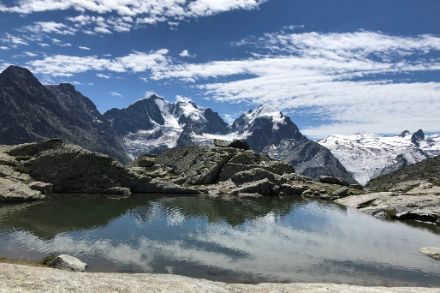 Vergletscherte Berge bei blauem Himmel mit etwas Wolken.