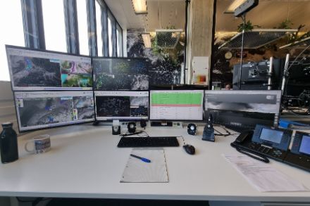 Foto eines Arbeitsplatz mit mehreren Bildschirmen.