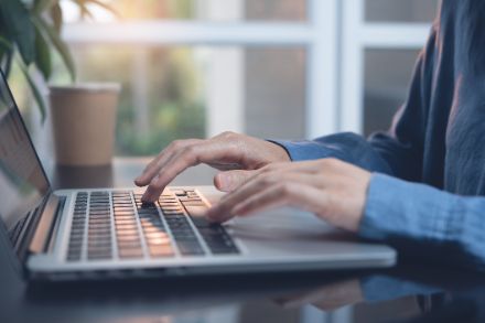 Ein Mann tippt auf einem Laptop. Seit 2014 konnten unsere Leserinnen und Leser Kommentare unter unseren Blogs hinterlassen. Bild: iStock. 
