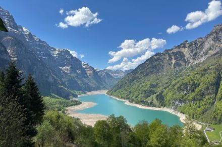 Stausee mit wenig Wasser in Gebirgslandschaft.