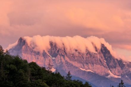 Foto einer Bergflanke mit Wolken, die an einen Wasserfall erinnern. 