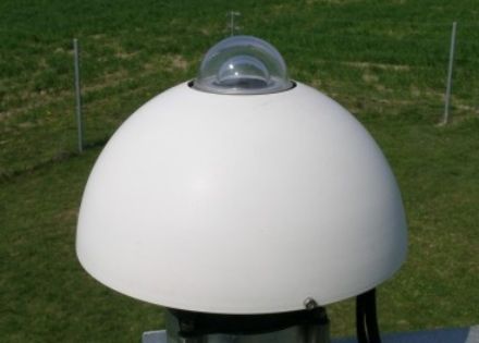 Eine kleine Glaskuppel, durch welche die Strahlung eintritt, umgeben von einem Abdeckschirm, der die Instrumente vor Umwelteinflüssen schützt.