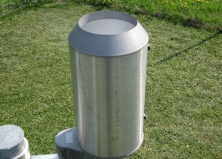 Zylinderförmiger, noch oben offener Auffangbehälter aus Metall.